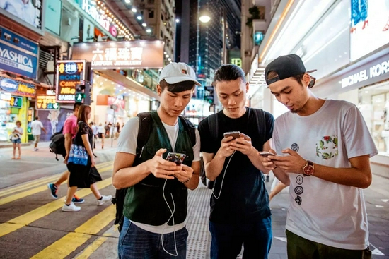 香港街头聚在一起玩手机的年轻人（视觉中国供图）