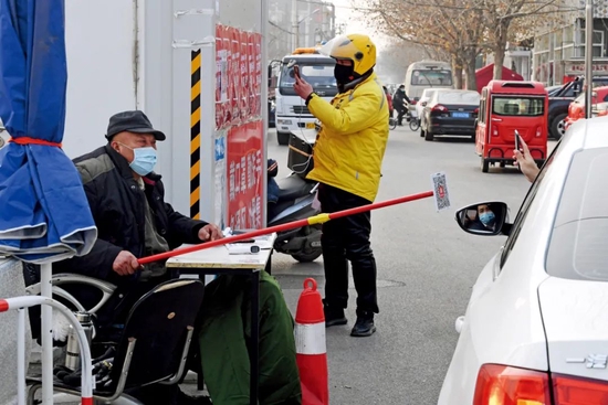 一些社区对进出车辆、人员要求扫描健康码登记行程。图/人民视觉