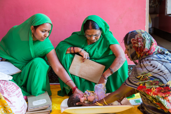 在印度举行的村庄健康营养日，卫生工作者正在给一名儿童称重 / 盖茨基金会
