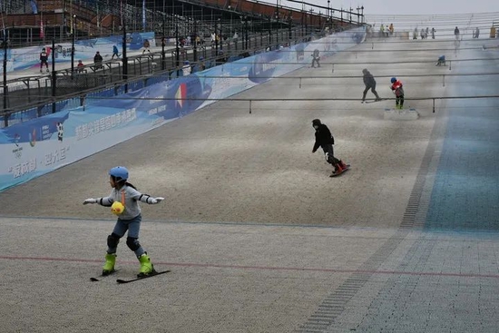 游客在成都“金针菇”旱雪滑雪场上感受冰雪运动的快乐。新华每日电讯记者谢佼摄
