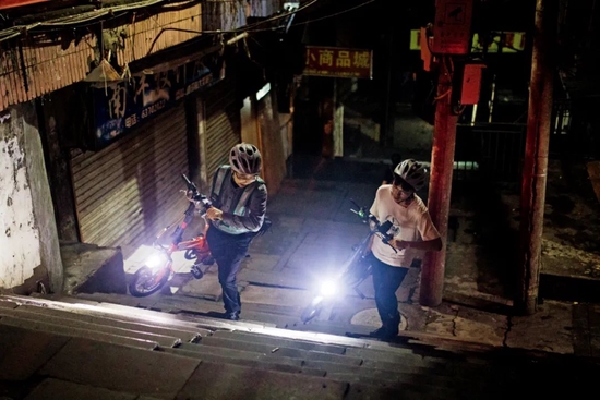 2020年6月13日，重庆市的一名代驾人员（左），带着体验代驾工作的儿子在深夜一起回家。图/IC