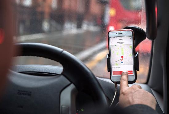 司机正在使用Uber应用程序 图源:彭博