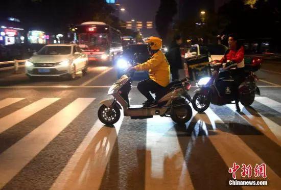 资料图:送餐路上的外卖配送员。中新社记者 吕明 摄