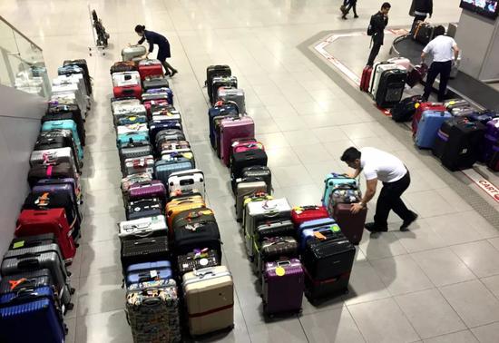 机场工作人员整理行李箱中。 图 / 网络