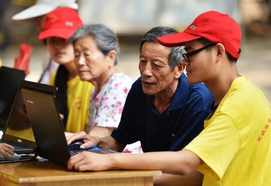 大学生党员志愿者教老年人用电脑上网。新华社记者 王晓 摄