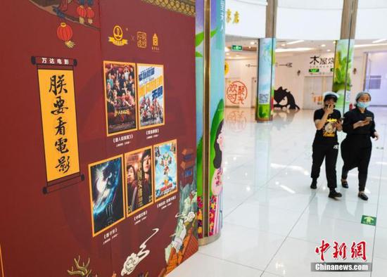 资料图：行人从暂未恢复营业的电影院前走过。中新社记者 侯宇