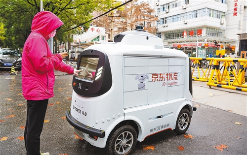 新冠肺炎疫情发生后，京东物流启用无人配送车为武汉市第九医院配送物资。图为该院医生在取快件。张武军摄（中经视觉）