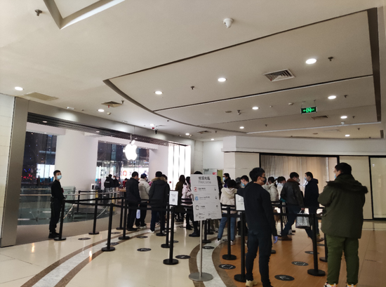 　　1月22日晚间，不少消费者在北京西单大悦城苹果体验店外排队等待 　　图片来源：每经实习记者 李明会 摄