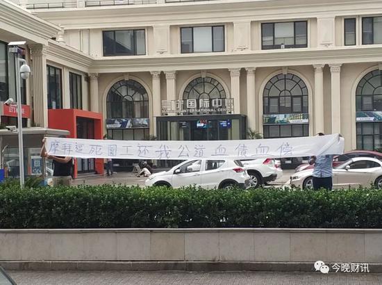 摩拜员工坠楼:一个摩拜员工之死 冯某的家属在摩拜楼前展示横幅