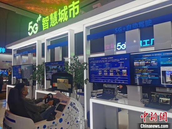 图为与会者模拟体验5G+自动驾驶 刘鹏 摄