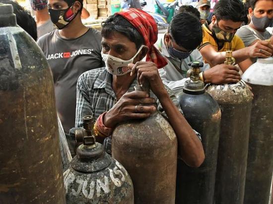 印度新德里的医疗机构里，许多人正在排队为COVID-19患者使用的氧气瓶换气。来源：Ishant Chauhan / AP / Shutterstock