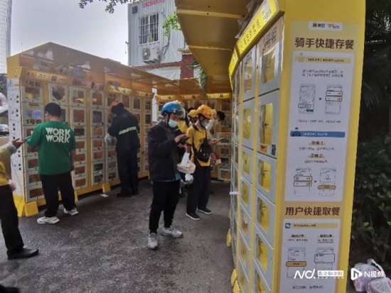 广州市区，骑手在智能取餐柜前存放外卖。