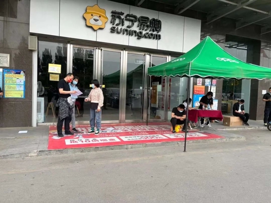 ▲北京某地商场门口，手机销售人员与顾客进行线下交易