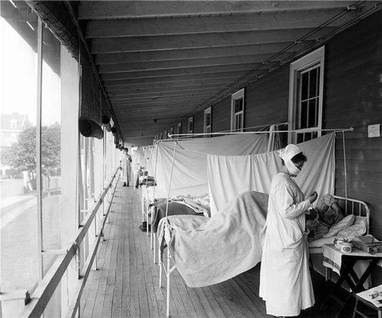  1918年西班牙流感暴发期间，一名护士在医院的流感病房里护理病人