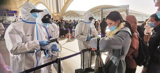 1月6日，河北石家庄火车站加强疫情防控，乘客凭核酸检测报告进站乘车。图/人民视觉