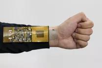 （手腕上的电子皮肤将脉冲读数发送至衣服上的接收器。图片来源：斯坦福官网Bao Lab)