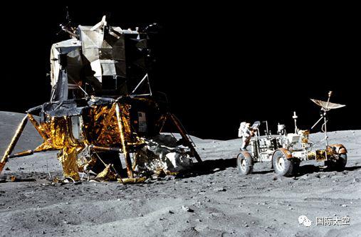 月面上的登月舱和月球车，航天员在月球车后面工作