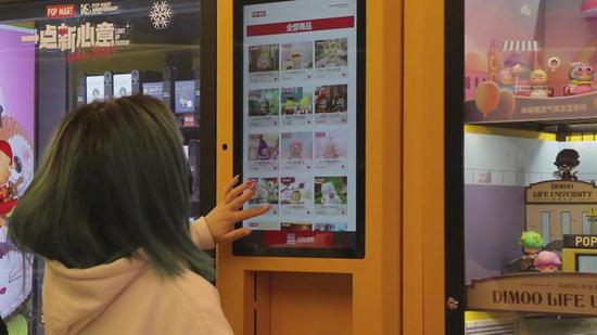 消费者在盲盒自动售卖机上挑选想要的盲盒系列。新华社记者 陆浩 摄