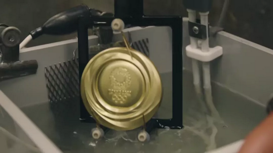金牌的电镀工艺流程（注意三个电流触点）（图片来源：奥组委官方Youtube）