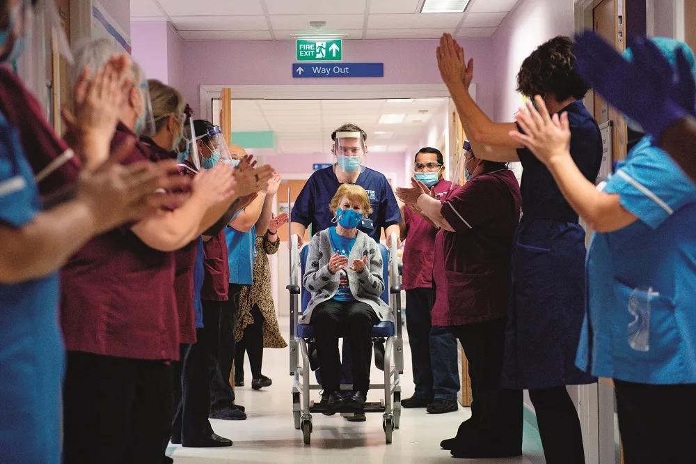 2020年12月8日，在英国考文垂，该国首位接种新冠疫苗者90岁的玛格丽特·基南接种后返回病房时受到工作人员的欢迎。图/人民视觉
