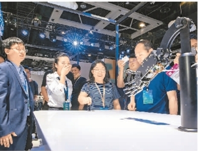 5月31日，在辽宁省沈阳市，第二届信息化展示大会的参会人员在与机械手臂互动。 　　张大为（人民视觉)