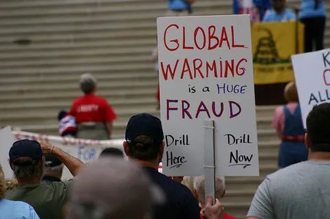 民众举着“全球变暖是谎言”的牌子，呼吁立刻开采化石燃料