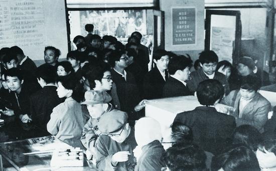 (图:1987年海尔电冰箱展销会,吸引了多多消耗者列队购买)