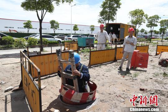 国家电网上海电力工作人员在特斯拉上海工厂外下井作业。张亨伟 摄