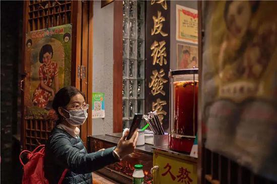 2020年10月28日，北京街边一商铺，顾客正在扫码付款。扫码付款已经成为国内各地消费者的一种习惯（视觉中国供图）