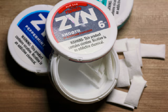 Zyn 尼古丁口含袋成品外包装示意图，包装附有尼古丁健康警示标签。