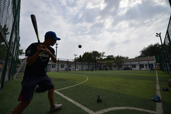 孩子们在pko跨界空间笼式足球场内参加暑期棒球培训班。