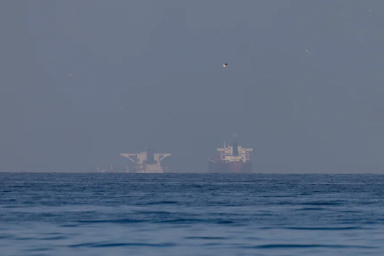 2026 年 3 月 22 日，阿拉伯联合酋长国哈伊马角北部、霍尔木兹海峡附近的海湾区域，多艘商船停泊于此。