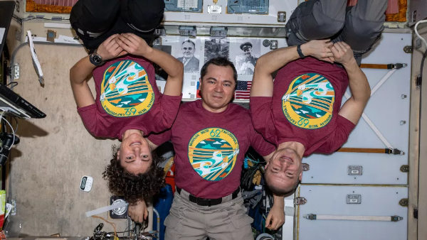 2020年2月7日，62号太空探险队3名成员：奥列格·斯克里波奇卡、杰西卡·梅尔和安德鲁·摩根，他们身穿带有任务标志的T恤在国际空间站合影。