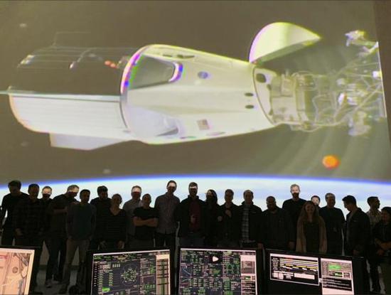 3月3日，在美国加利福尼亚州的霍索恩，工作人员观看大屏幕显示载人版“龙”飞船与国际空间站对接画面。新华社 图