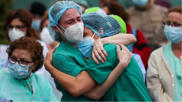 西班牙一名医护同事去世后，医护人员拥抱在一起，非常痛苦。