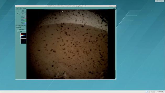 探测器以极快的速度传回了第一张拍摄的图像，展示的是远处的火星地平线，拍摄时半透明的防尘盖尚未去除，因此可以看到沾满尘埃的镜头画面。