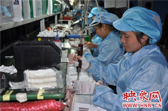 富士康员工在投影仪流水线上组装投影仪