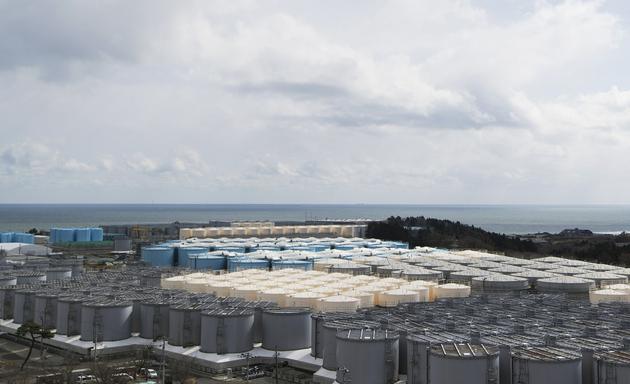 这张摄于2021年2月27日的图片显示了福岛第一核电站的储水罐（灰色、米色和蓝色），里面储存着用于冷却乏燃料的水。尽管经过处理，但这些水仍具有放射性