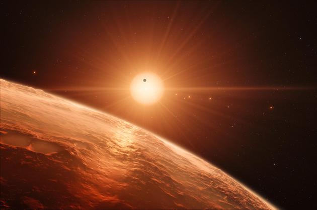 艺术想象图：从TRAPPIST-1系统中的一颗行星表面眺望远处的恒星TRAPPIST-1，画面中也可以看到其他几颗行星