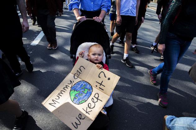 图为2019年9月20日在悉尼举行的一次气候变化游行中，一名婴儿手中拿着一块写有标语的牌子。