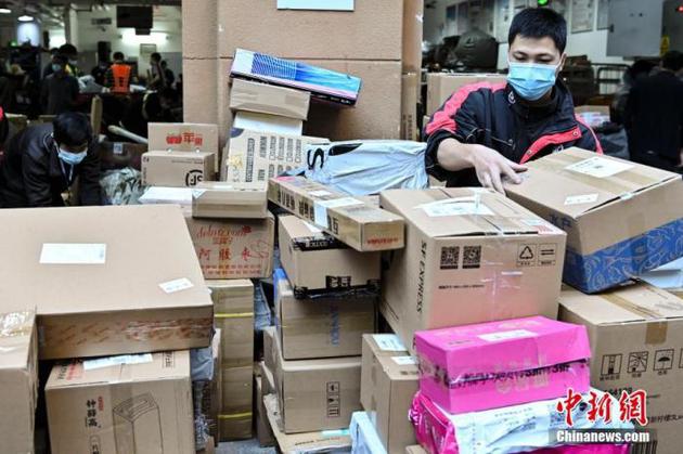 资料图：11月12日，广东省广州市，一名快递员在快递网点整理将要派送的快件。 中新社记者 陈骥旻 摄