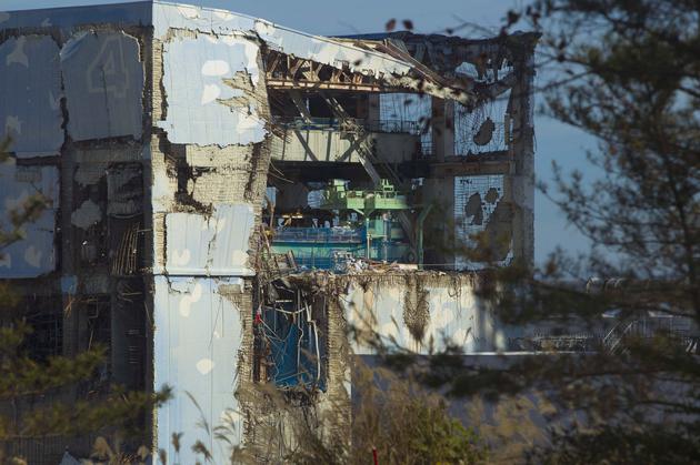 这是2011年11月12日的资料图片。当媒体记者第一次被允许进入日本被海啸破坏的福岛第一核电站时，他们从一辆巴士的车窗看到了受损的4号反应堆