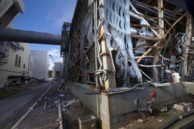 这是2011年11月12日的资料照片。在日本福岛县大隈镇，媒体被允许进入被海啸破坏的核电站，这是自3月11日灾难以来第一次拍摄到福岛第一核电站的受损情况。1—3号反应堆的堆芯熔毁事故使核电站看起来就像战区被炸毁的工厂。紧急救援人员冒着生命危险进行着善后工作，试图阻止这场严重的核危机失控