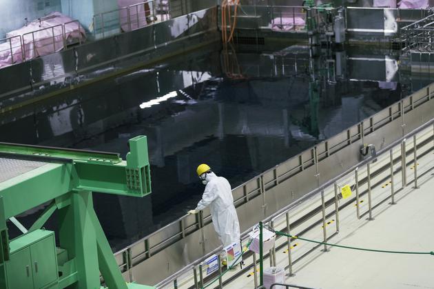 2021年2月27日，东京电力公司的一名工作人员正在察看一个临时的冷却池，其中装有来自福岛第一核电站反应堆的乏燃料