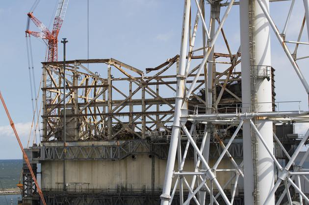 这张照片显示的是福岛第一核电站受损的1号反应堆，后面是1号和2号反应堆共用的排气管，摄于2021年2月27日