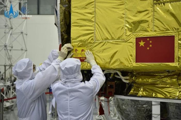 工作人员正在火星环绕器上安装会徽。图片来源：中国探月工程微信公众号