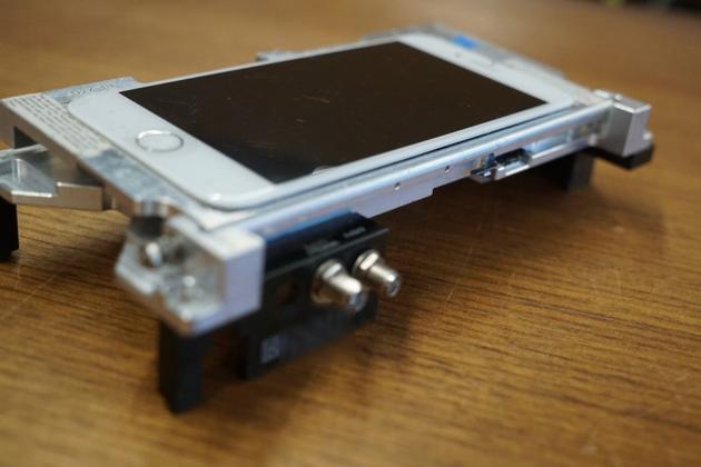 一台安装在支架上的“dev-fused”版iPhone(Image: Motherboard)