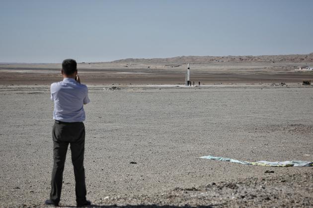 △ 游人们站在戈壁滩上远观拍摄火箭发射。