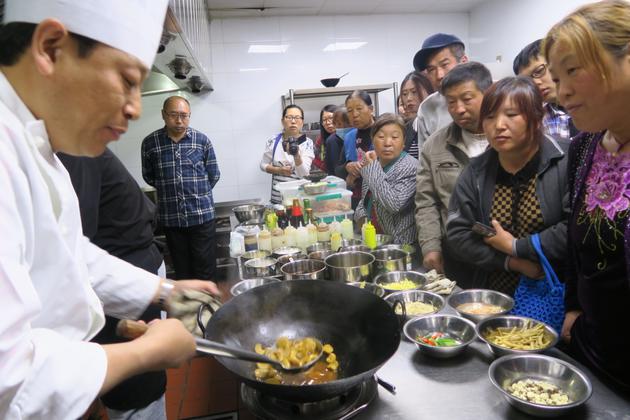 ▲刘宇邀请专业烹饪师傅到东村传授蘑菇菜的烹饪技法