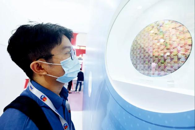 参观者在2020中国国际半导体博览会上观看中芯国际生产的芯片。图/IC